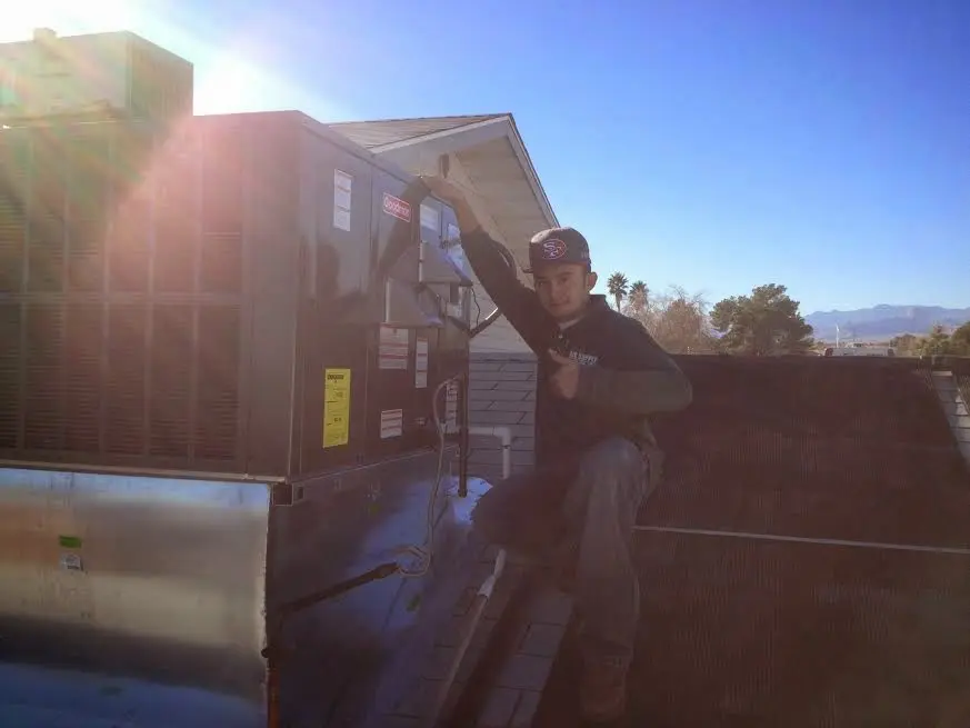HVAC technician performing AC Tune-Up on a rooftop unit in Wentzville