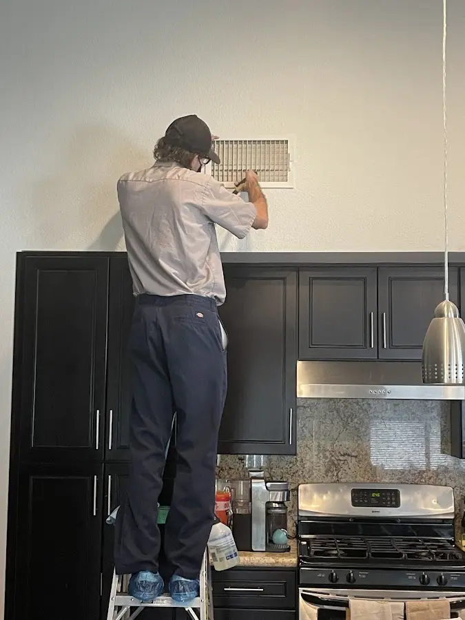 Technician inspecting an air vent during HVAC service in Wentzville